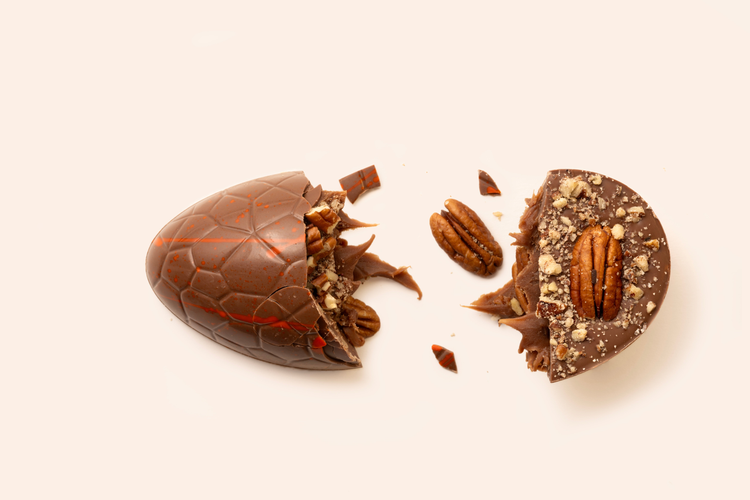 Drie gevulde chocolade paaseieren belegd met verse noten